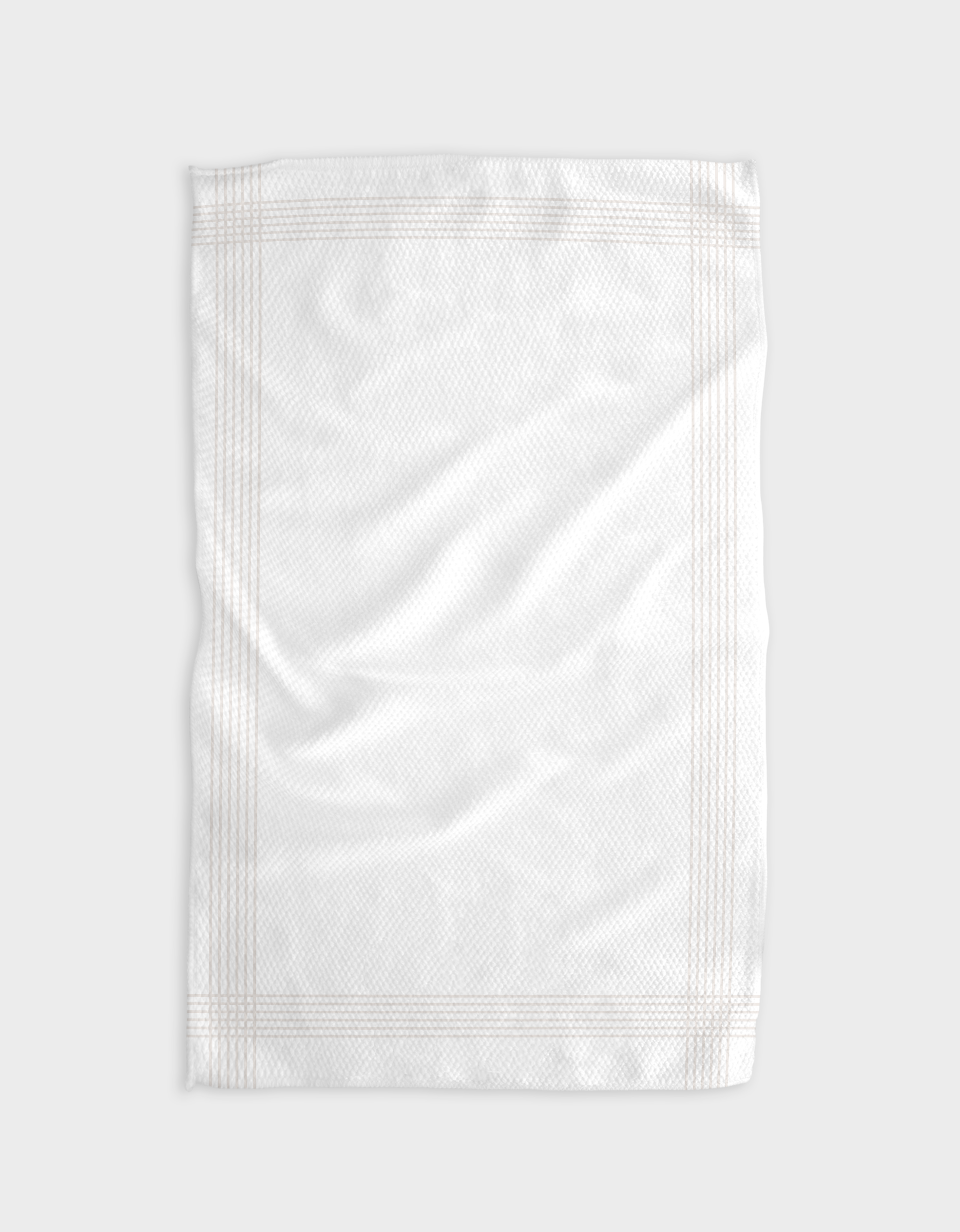 Borderline - Beige by The Buy Guide is a plain white tea towel made from recycled materials, with a subtle textured pattern and faint border lines, shown flat on a light gray surface with gentle folds and wrinkles.