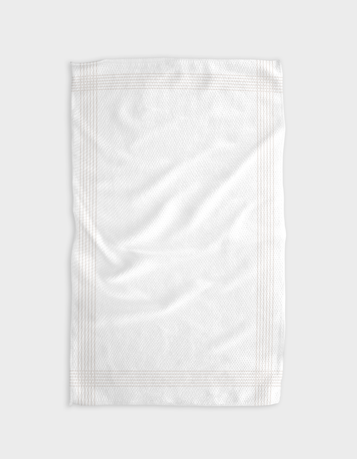 Borderline - Beige by The Buy Guide is a plain white tea towel made from recycled materials, with a subtle textured pattern and faint border lines, shown flat on a light gray surface with gentle folds and wrinkles.
