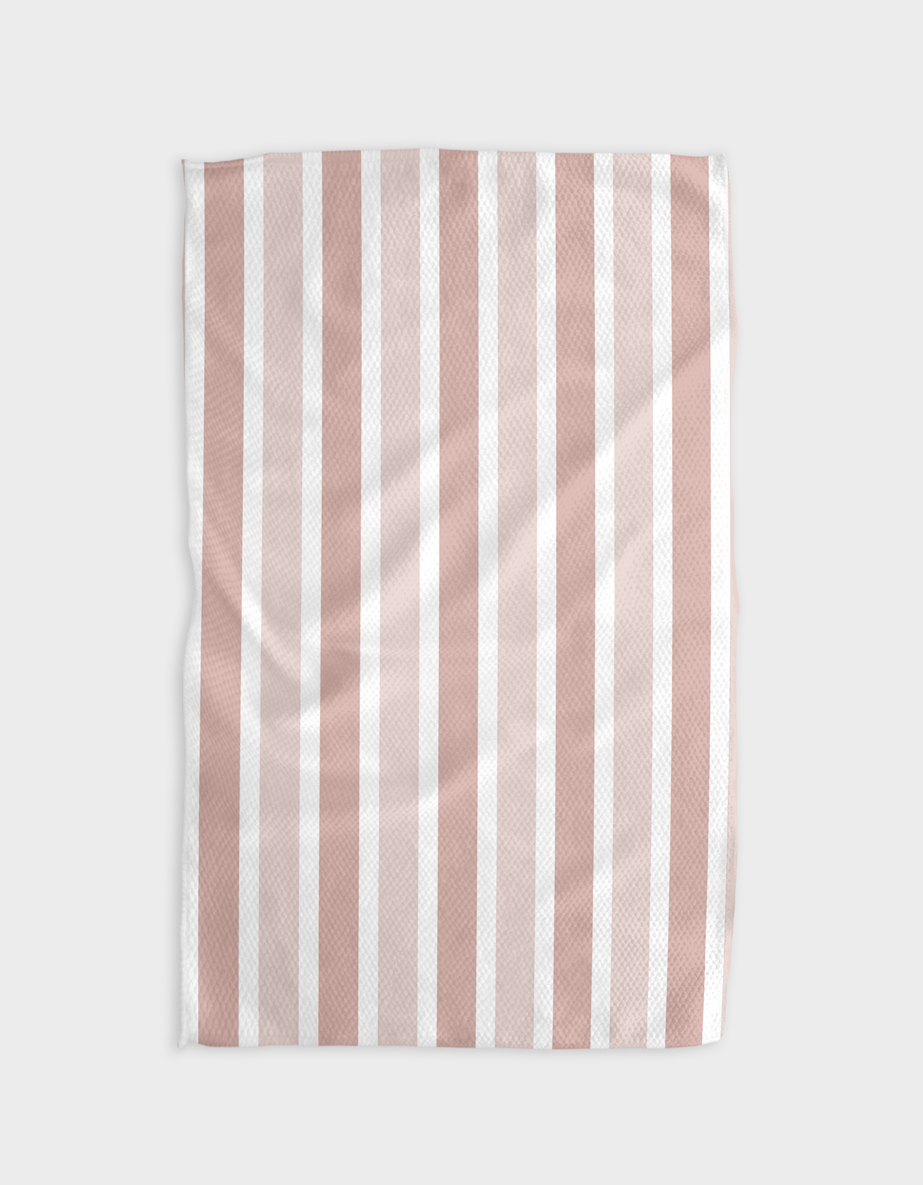 The Buy Guide’s Earn Your Stripes - Dusty Rose blanket, made from soft Geoweave fabric with vertical pale pink and white stripes, is shown on a light gray background. Its smooth surface features gentle folds and creases.