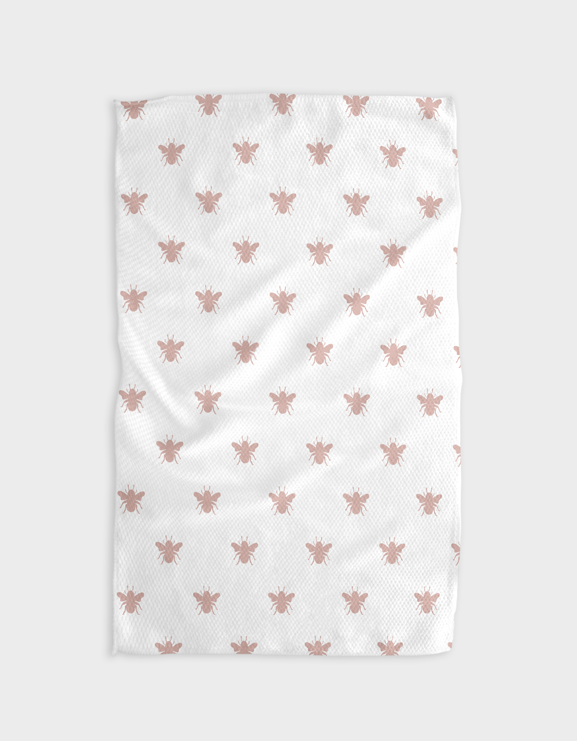 The Buy Guide’s Queen Bee - Dusty Rose tea towel is white with a textured, slightly wrinkled surface and features a repeating pattern of small, light pink bees. Made from recycled materials, its plain background highlights the charming design.