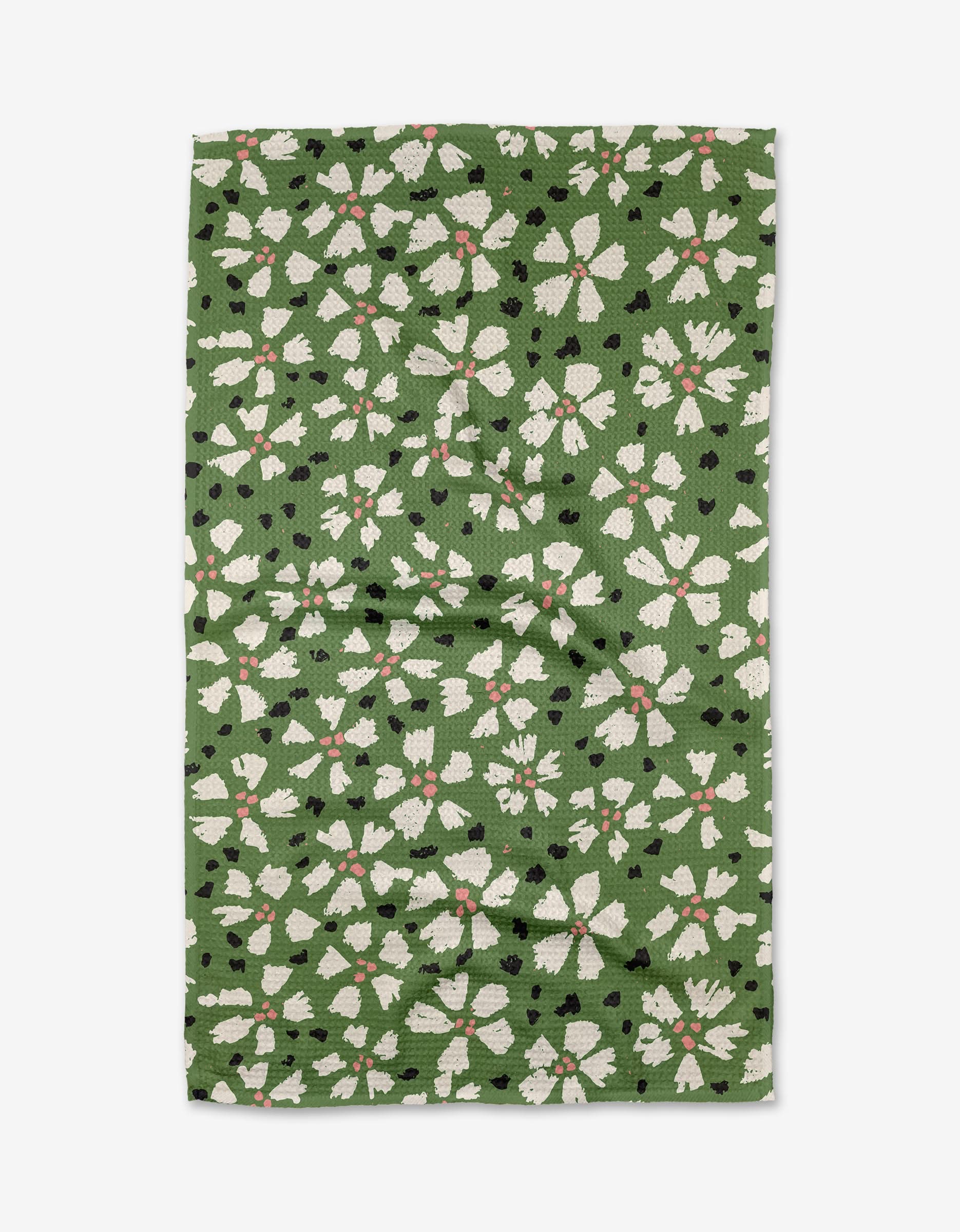 Aster by Kayla Ann: an eco-friendly green Geoweave tea towel with white and light pink floral patterns and scattered black dots, made from recycled materials.