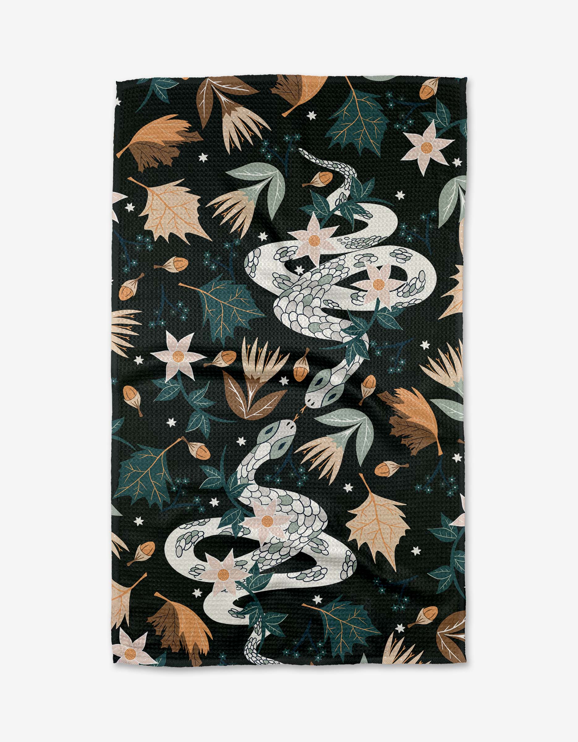 The Autumn Snakes Tea Towel by Julianne Haness features white snakes amid autumn leaves, flowers, stars, and foliage in muted green, beige, and brown on a dark background. Made from recycled materials.