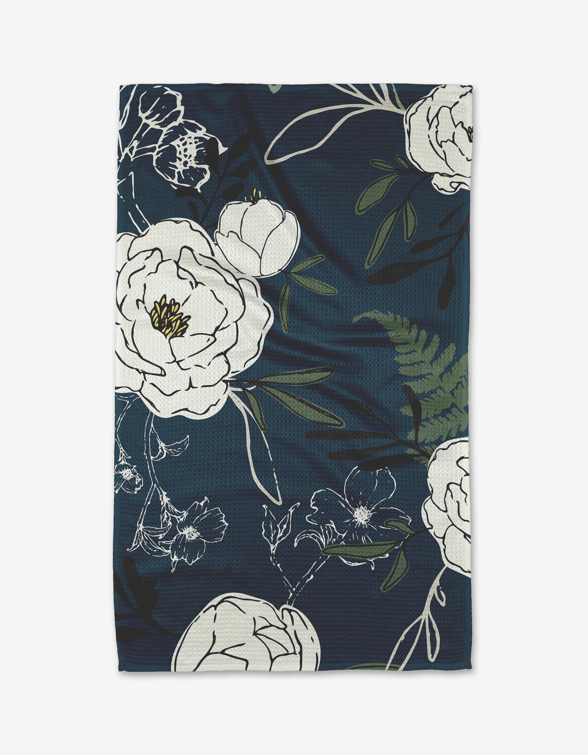 The Blooming Possibilities tea towel by Ashley Celena features a dark blue Geoweave fabric with large, bold-outlined white flowers and green leaves arranged artistically for ultra-absorbency.