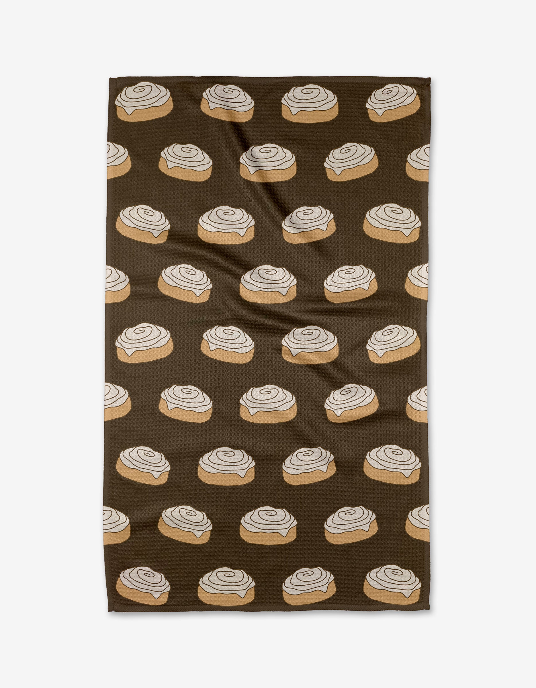 The Purely Kaylie Cinnamon Girl towel, made from ultra-absorbent Geoweave fabric, showcases a repeating print of cinnamon rolls with white icing across its brown surface.