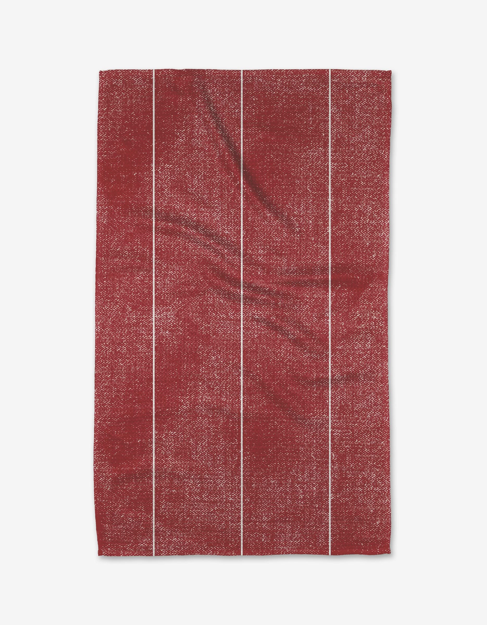 The Becki Owens Cinnamon tea towel is a red, rectangular, ultra-absorbent kitchen towel made from recycled materials. It features four thin white vertical stripes, visible creases, and a subtle mottled texture.