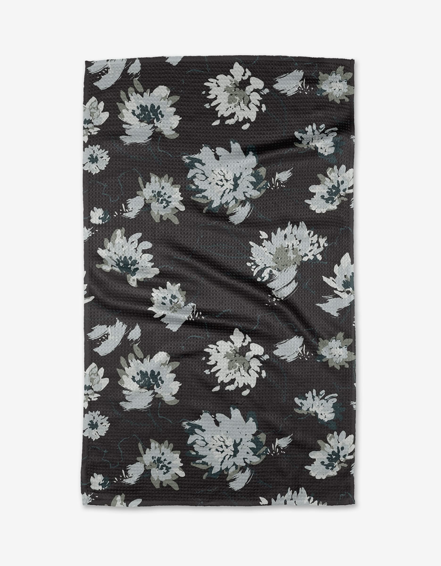Daydreams by Toboggan Avenue is a black Geoweave™ tea towel with elegant white and gray floral patterns, featuring large painterly blooms. Eco-friendly and textured, it’s a stylish kitchen essential.