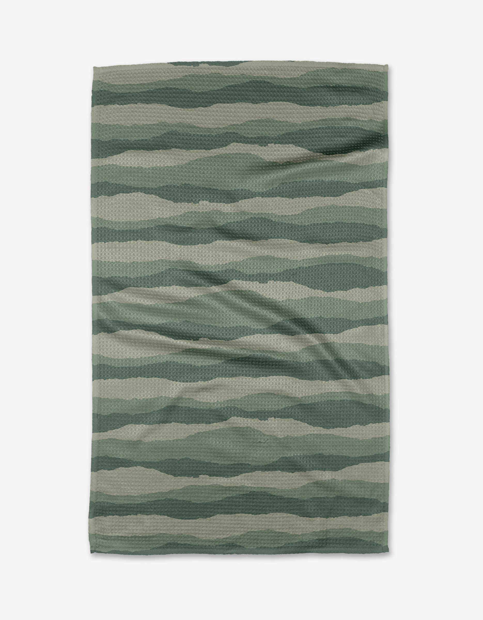 The Distant Landscape tea towel by Twig + Spark features a wavy green striped pattern on textured fabric made from recycled materials, shown laid flat on a white background.