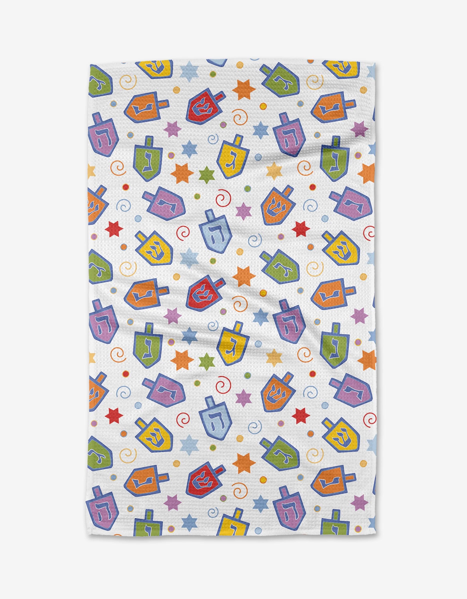 The Dreidel Dreidel Dreidel tea towel by Mindfulnice features a festive Hanukkah pattern with colorful dreidels, stars, and spirals on ultra-absorbent white fabric.