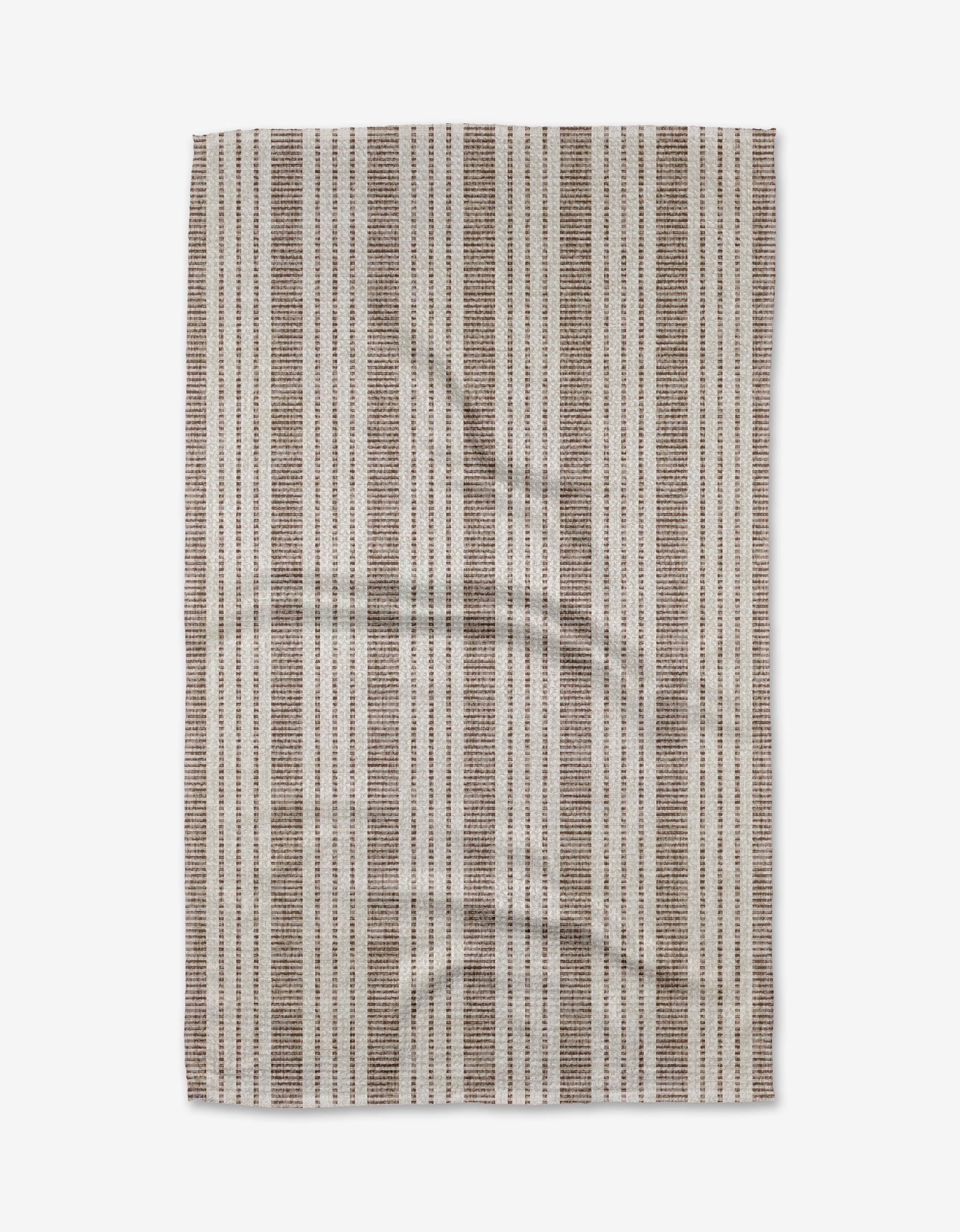 The Becki Owens Dyer Rust towel, made from ultra-absorbent Geoweave fabric, features vertical brown, beige, and off-white stripes and is shown neatly laid flat on a white background.