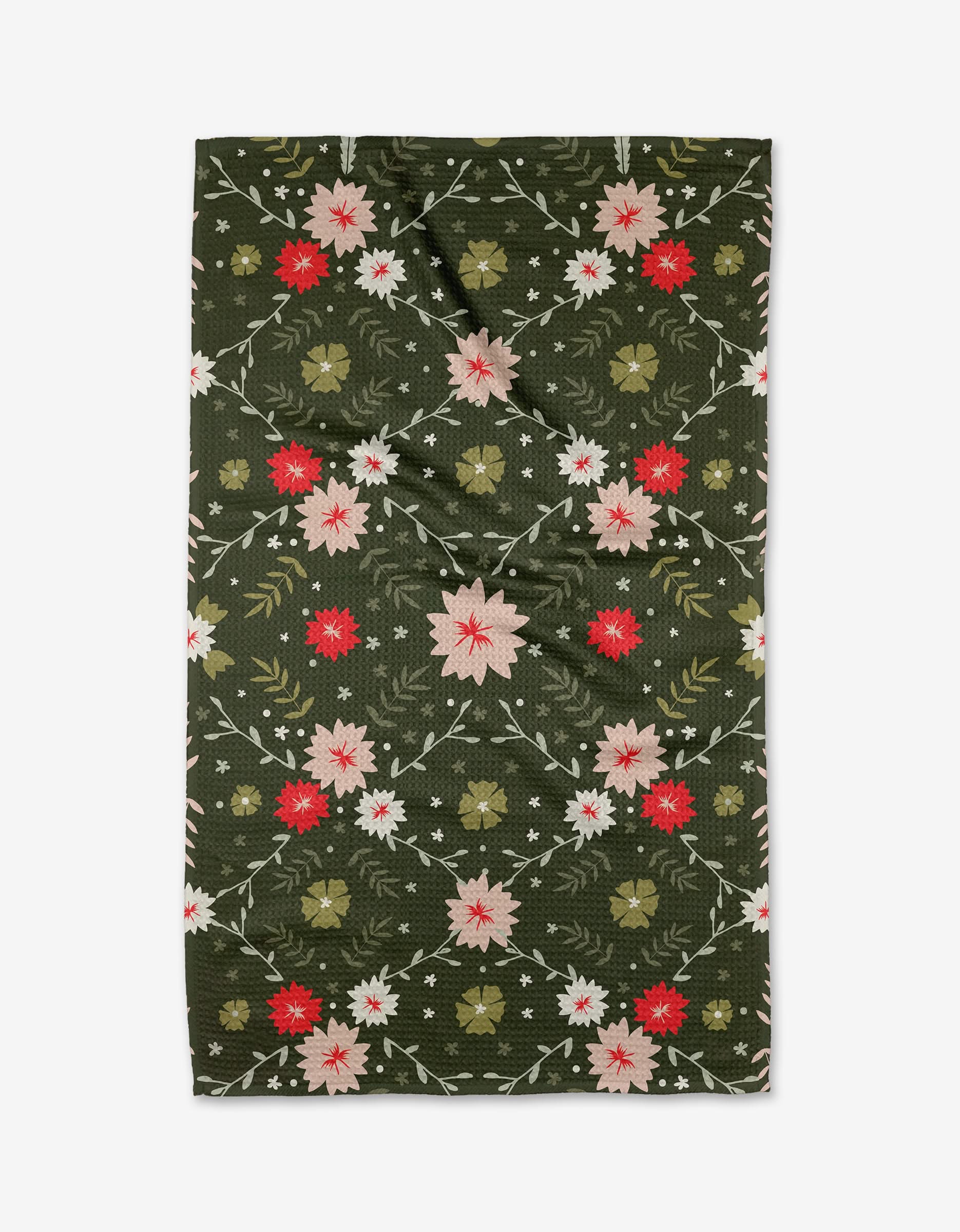 The Festive Forest tea towel by Ash Cascade is a rectangular, dark green, ultra-absorbent towel with a symmetrical pink, red, and beige floral pattern on green leaves. Made from recycled materials, it has a slightly wrinkled appearance.