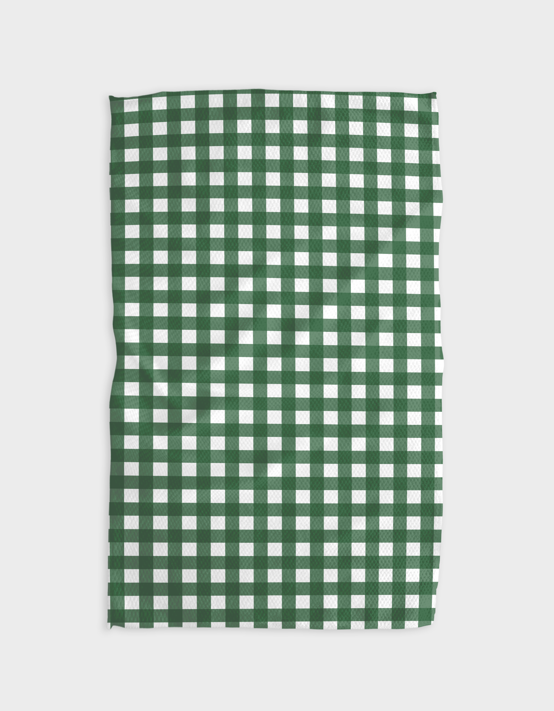 The Gigi - Evergreen by The Buy Guide is a rectangular tea towel in a green and white check pattern, laid flat on a white background. Made from Geoweave fabric, its edges have a subtle wave.