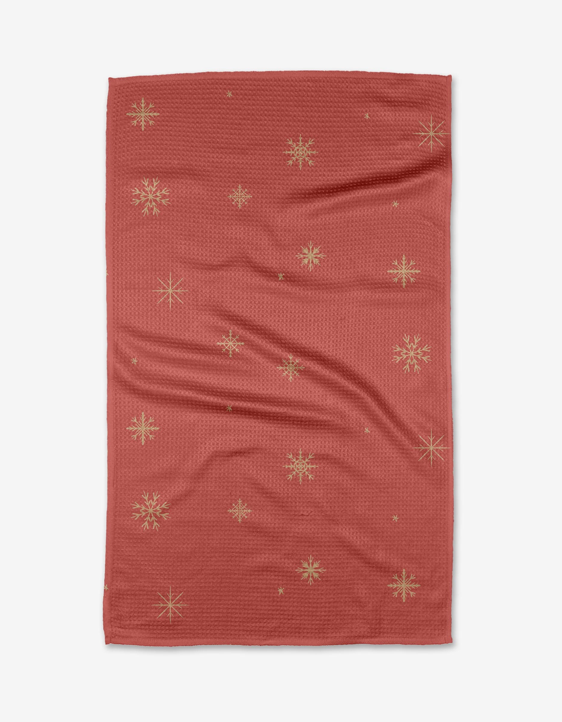 The Golden Snowflakes tea towel by Janna Sue Design features gold snowflake patterns on red, crafted from quick-drying recycled materials and displayed on a white background.