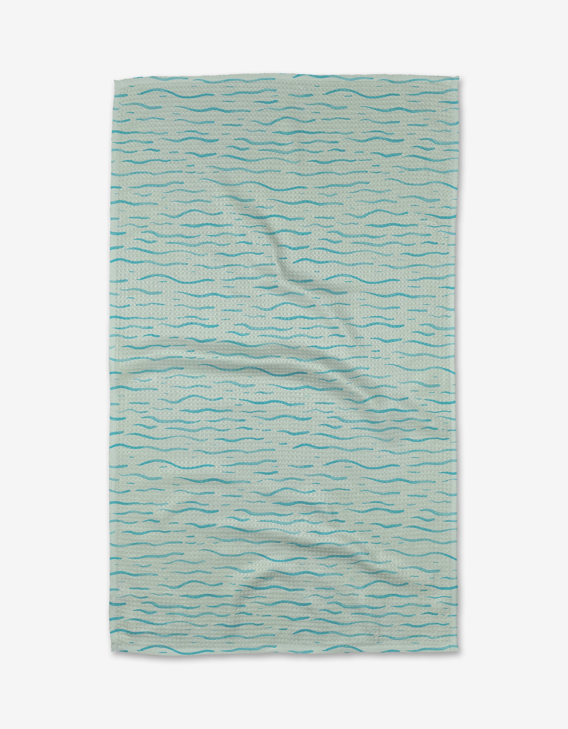 The Just Keep Swimming tea towel by Katie OShea is light blue, rectangular, and made from Geoweave™ fabric. It features a wavy, water-inspired pattern in dark blue tones and is shown slightly wrinkled on a white background.