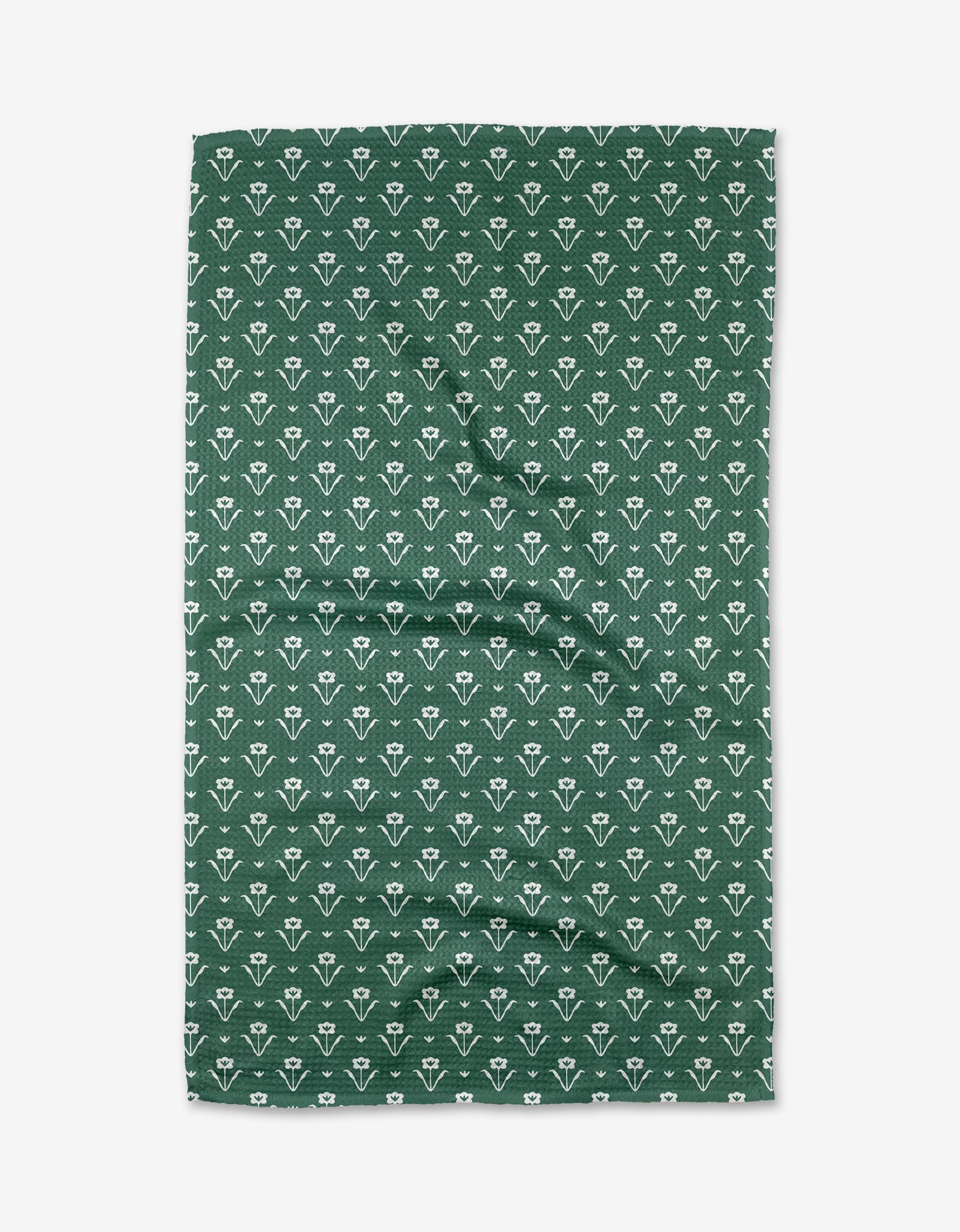 The Buy Guides Ladylake - Evergreen Tea Towel features a repeating white floral pattern on green Geoweave™ fabric, offering durability and absorbency. Photographed laid flat with visible creases.