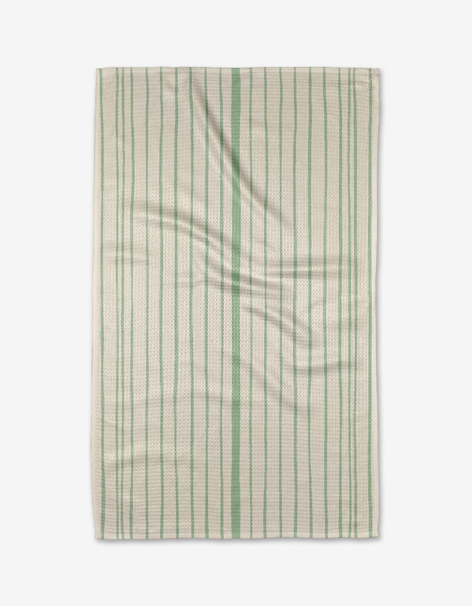The Becki Owens Lily Stripe dish towel features a rectangular white design with ultra-absorbent, textured fabric and green vertical stripes, shown lying flat with gentle folds.