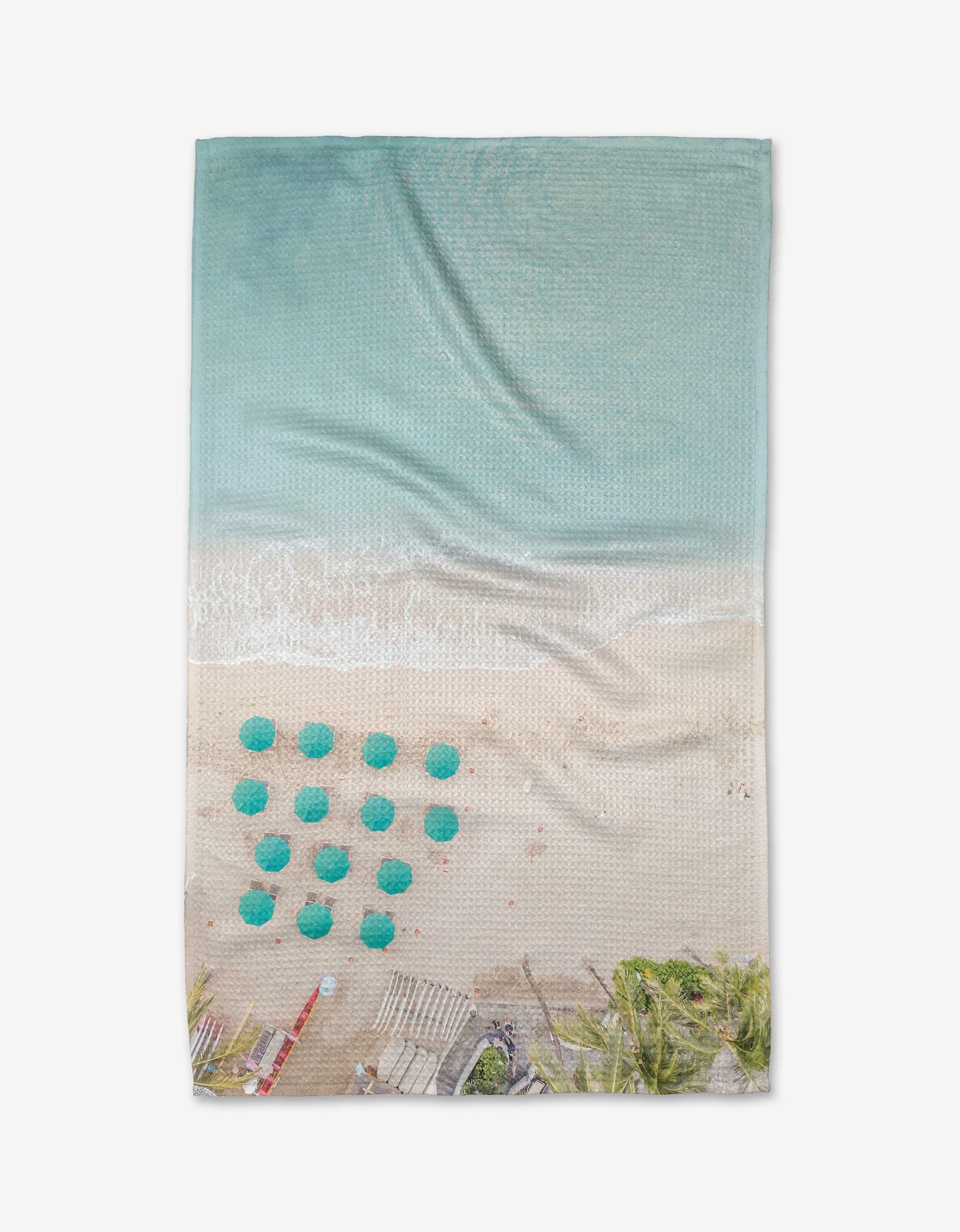 Aerial view of a beach with turquoise water, white sand, green umbrellas, and palm trees—captured in stunning detail on the Love From Hawaii tea towel by Kait Hanson. Made from recycled materials with premium Geoweave™ fabric.