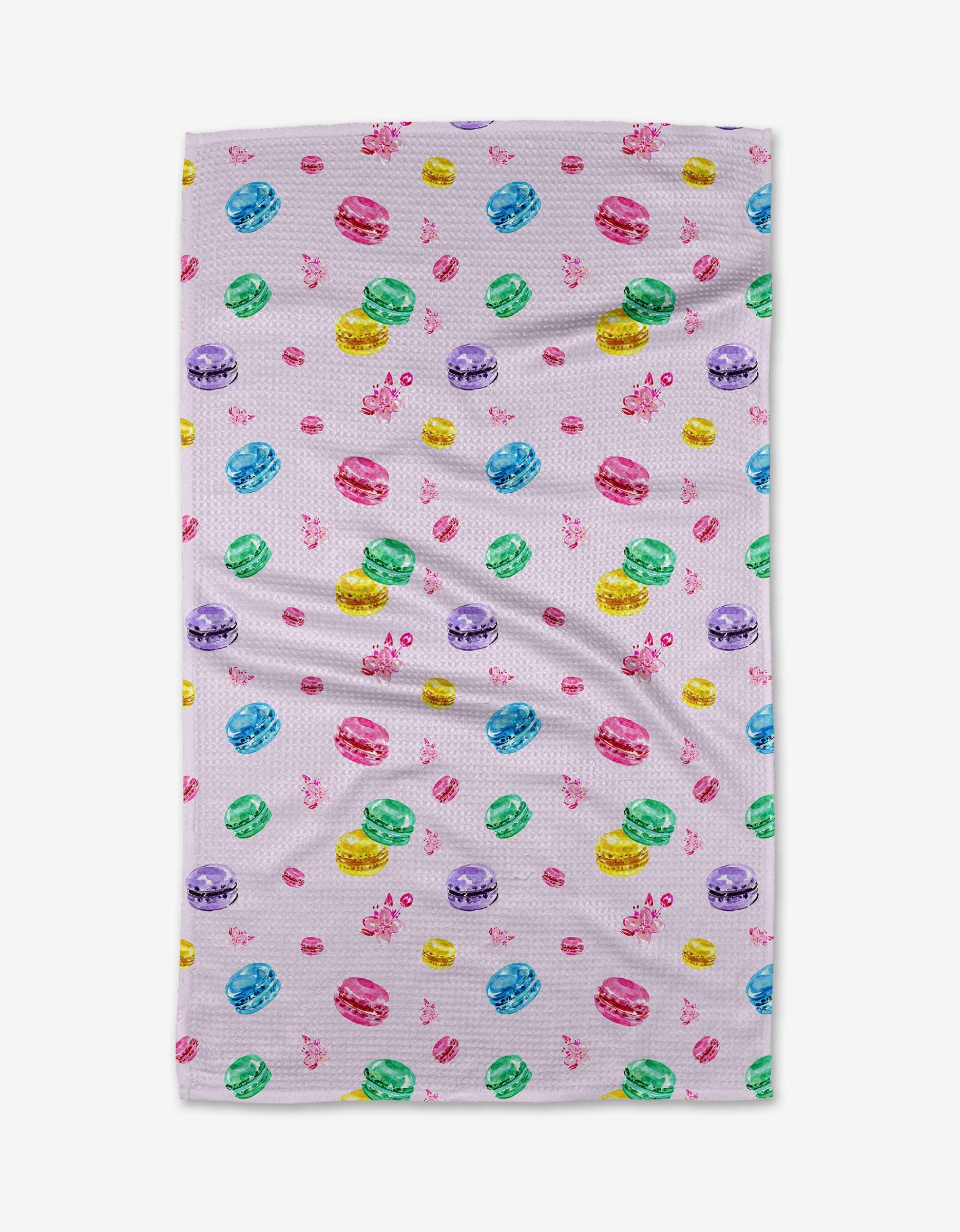 The Macarons in Paris tea towel by Travel Write Draw features a white background adorned with colorful macarons—pink, yellow, green, blue, and purple—and playful pink bows.