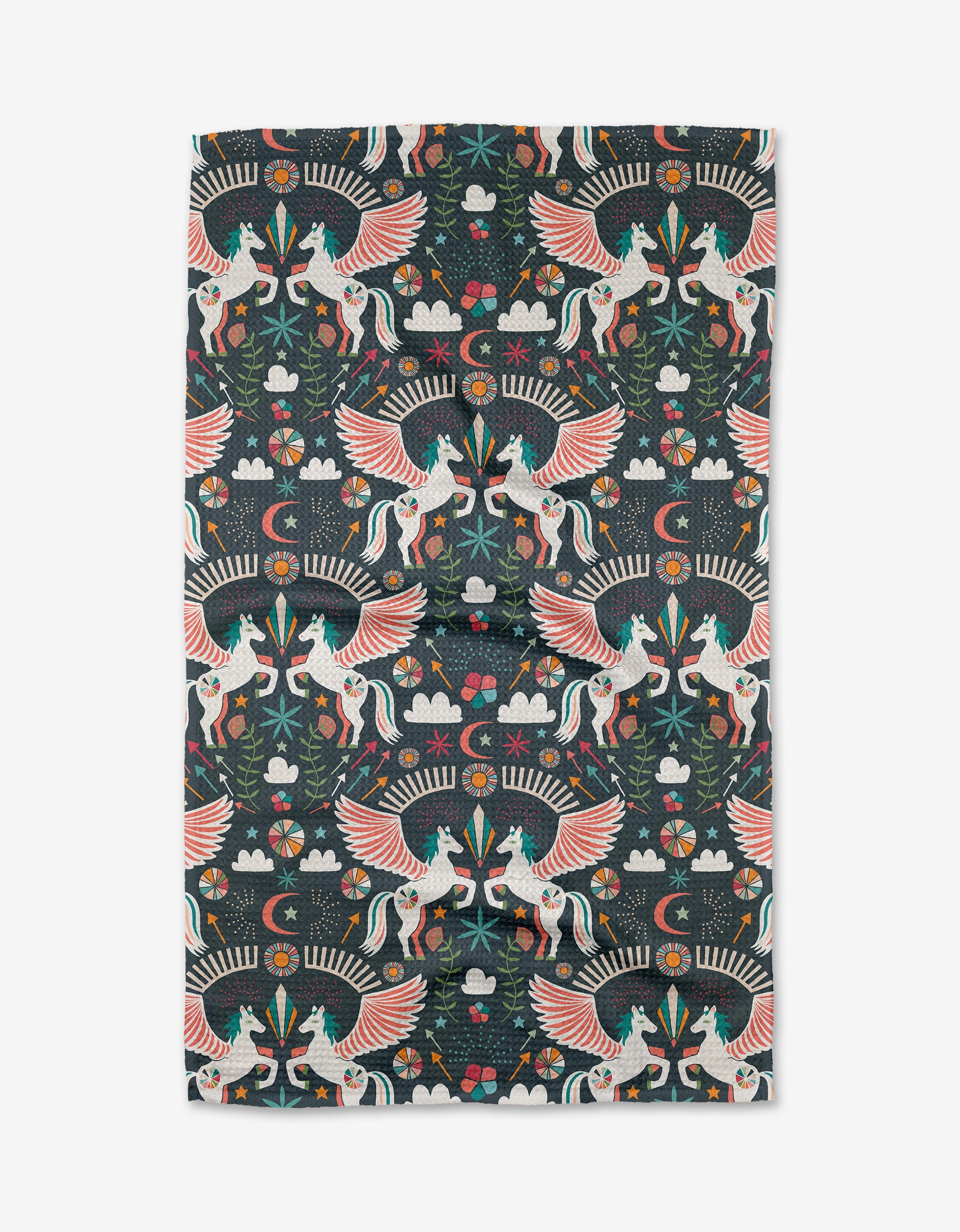 Jessica Swift’s Magical Moments kitchen towel showcases colorful winged unicorns, flowers, stars, clouds, and foliage in a symmetrical folk-art style on a dark background.