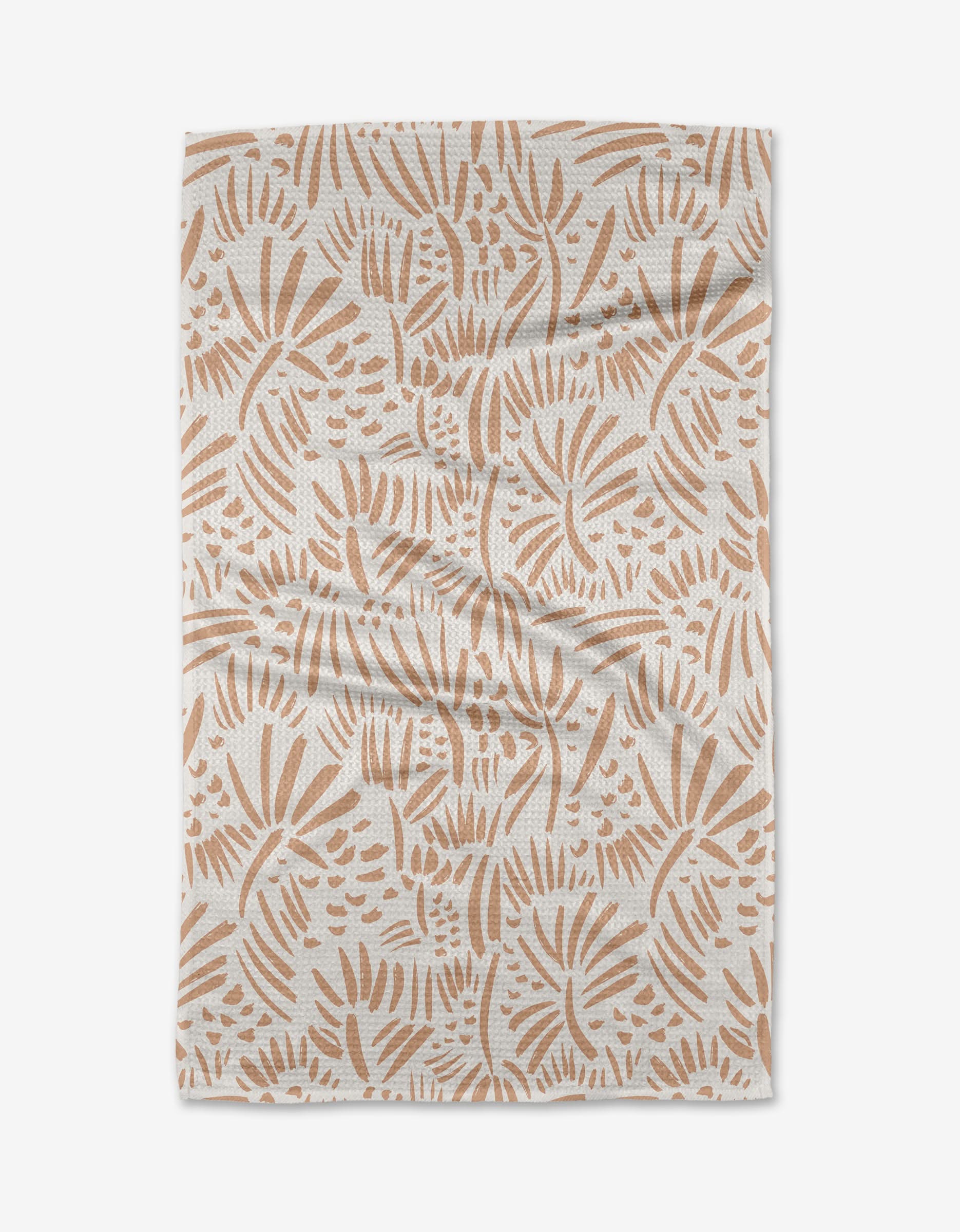 The Miami tea towel by Hufton Studio is a rectangular white piece made from recycled materials, featuring light brown abstract leaf and botanical patterns with visible creases and folds.