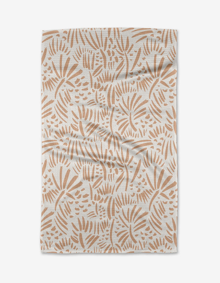 The Miami tea towel by Hufton Studio is a rectangular white piece made from recycled materials, featuring light brown abstract leaf and botanical patterns with visible creases and folds.