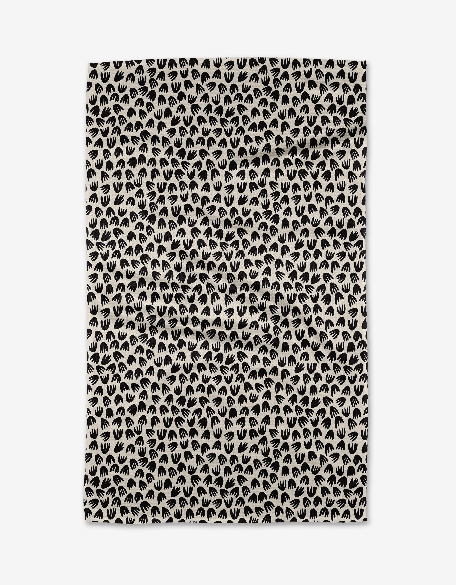 The Kayla Ann Microbloom is a beige rectangular tea towel with a repeating pattern of small black stylized handprints closely arranged across its ultra-absorbent surface.