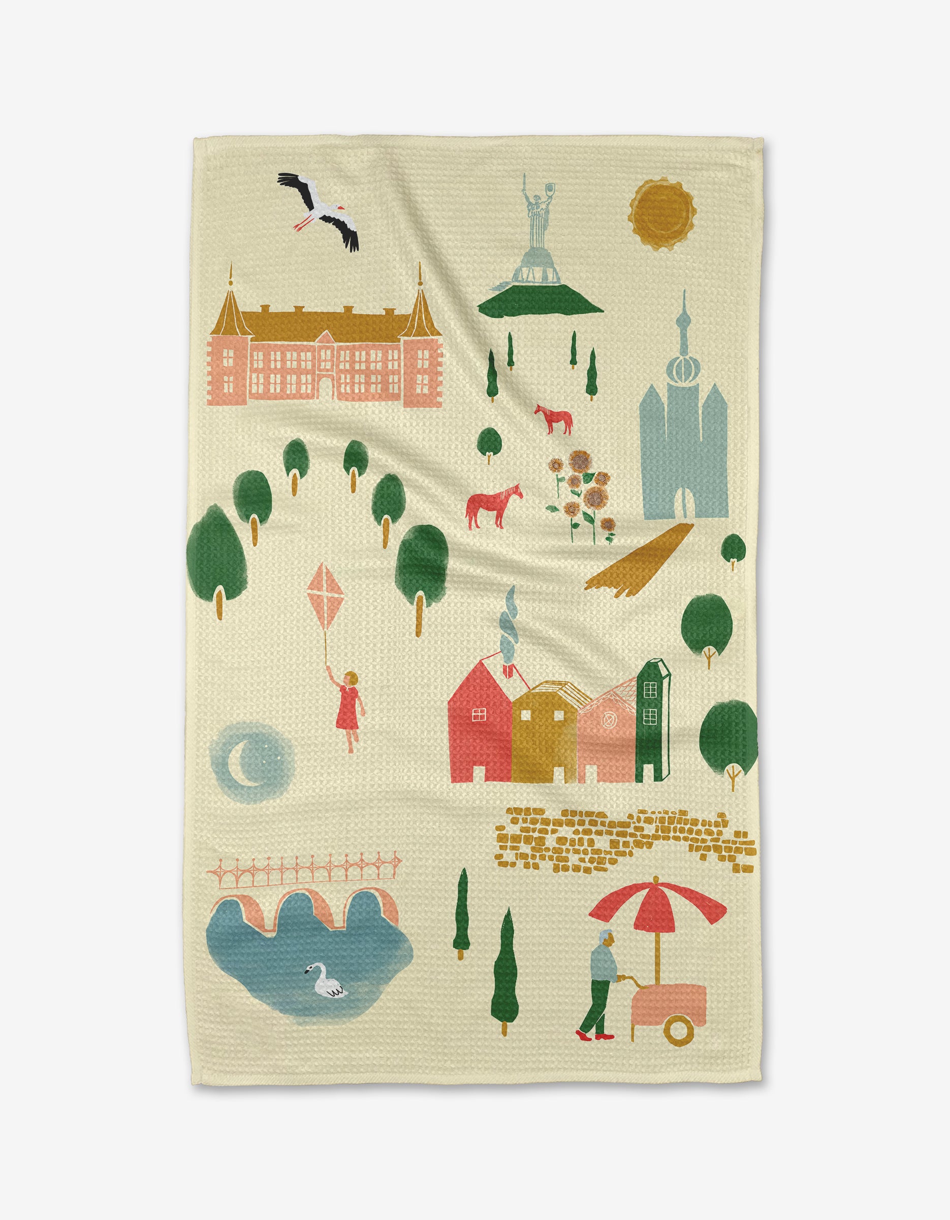 The Motherland Tea Towel by Elisabeth Wing, illustrated with vibrant houses, trees, and a castle, is crafted from sustainable Geoweave fabric in light beige—adding a charming, eco-friendly touch to your kitchen.
