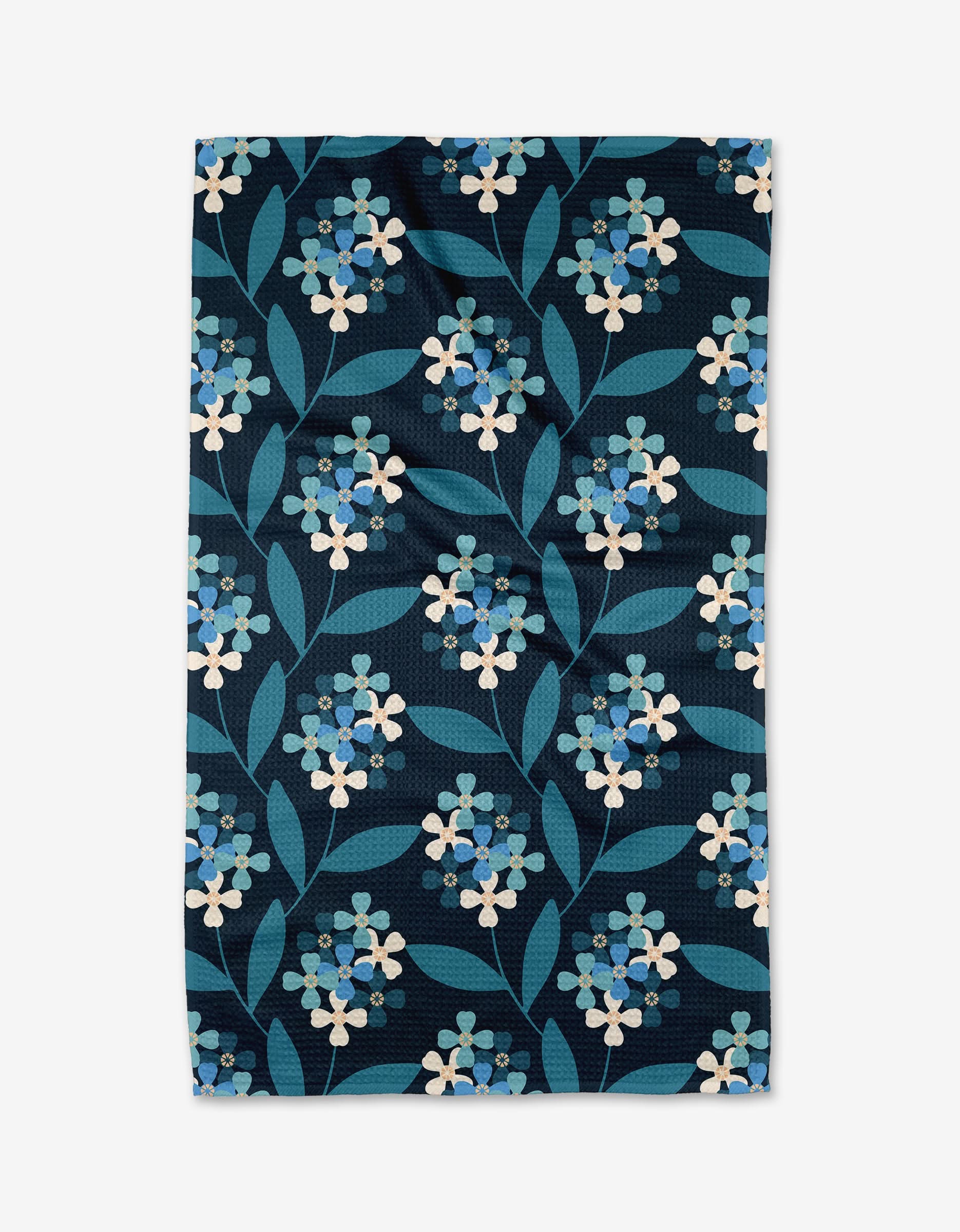 Nighttime Florals by Blissful Flamingo is a rectangular Geoweave fabric with an ultra-absorbent, dense, symmetrical pattern of light blue and white flowers with green leaves on a dark blue background.