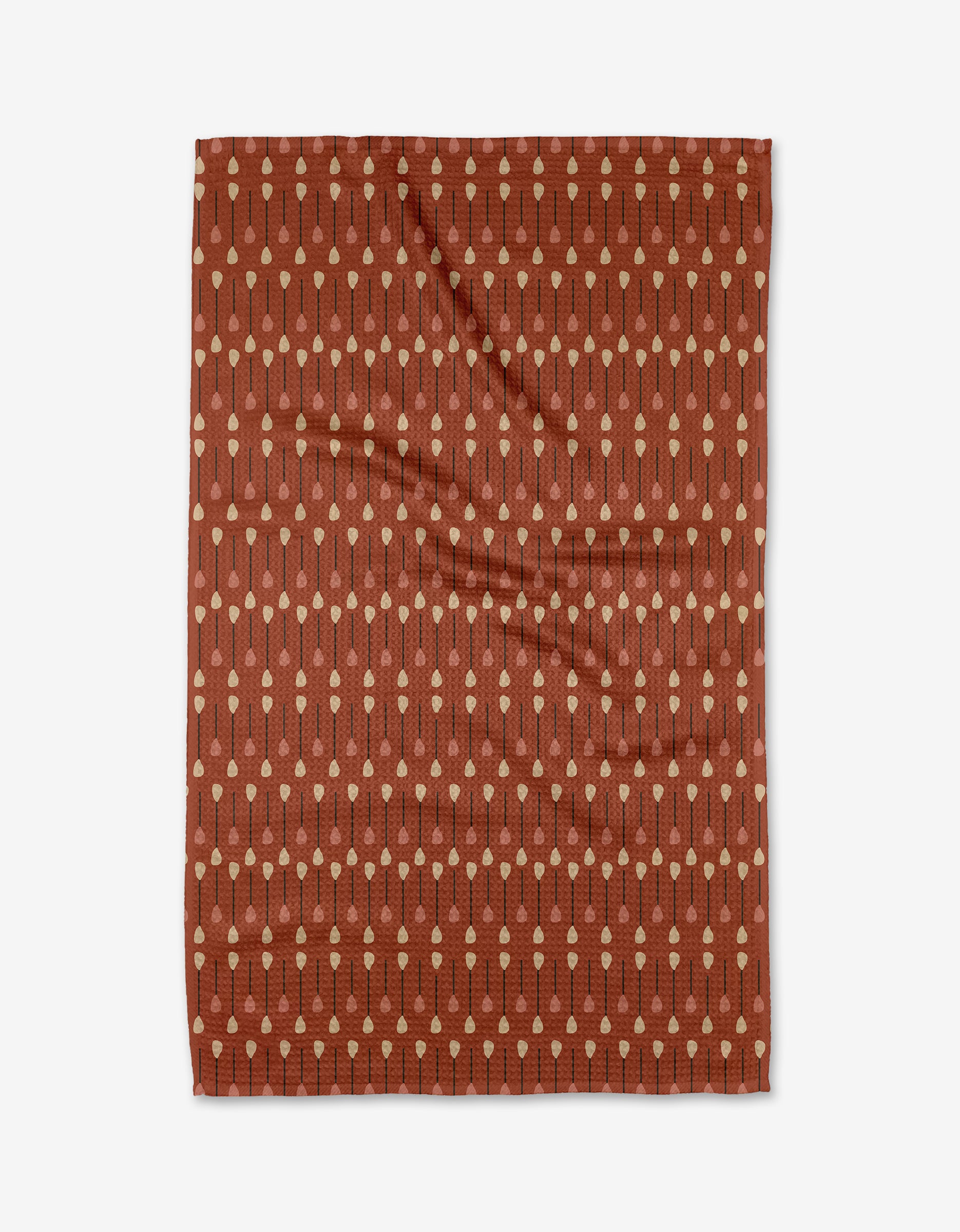 The Coit Creative Paddles and Oars tea towel is rust-colored, rectangular, and made from recycled materials, featuring beige dotted lines in a paddle-inspired pattern, shown flat on a white background.
