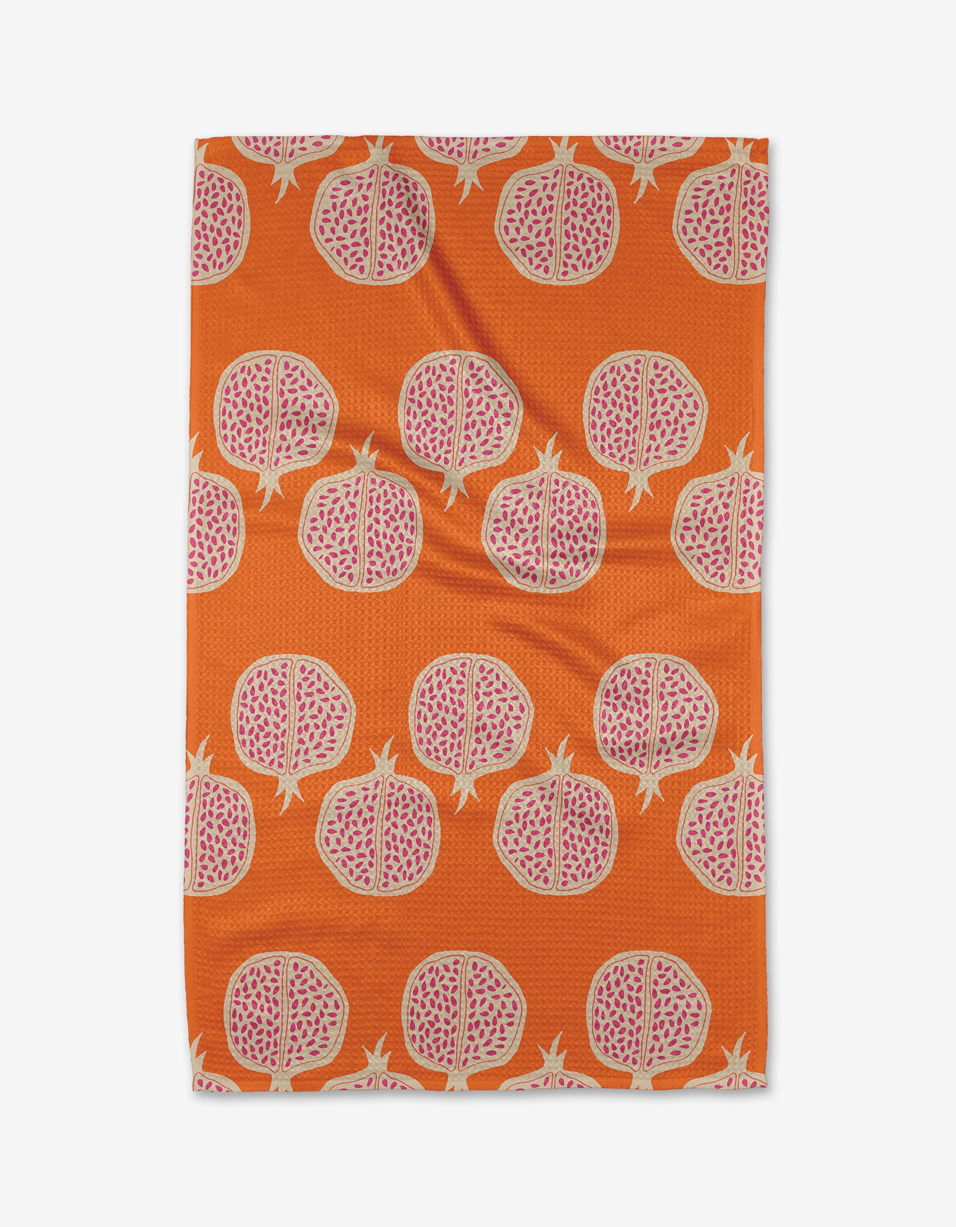 The Pomegranate Parade tea towel by Lizzie Clark is rectangular, ultra-absorbent, and made from recycled materials, featuring an orange backdrop with a repeating pattern of pink pomegranate halves and visible seeds.