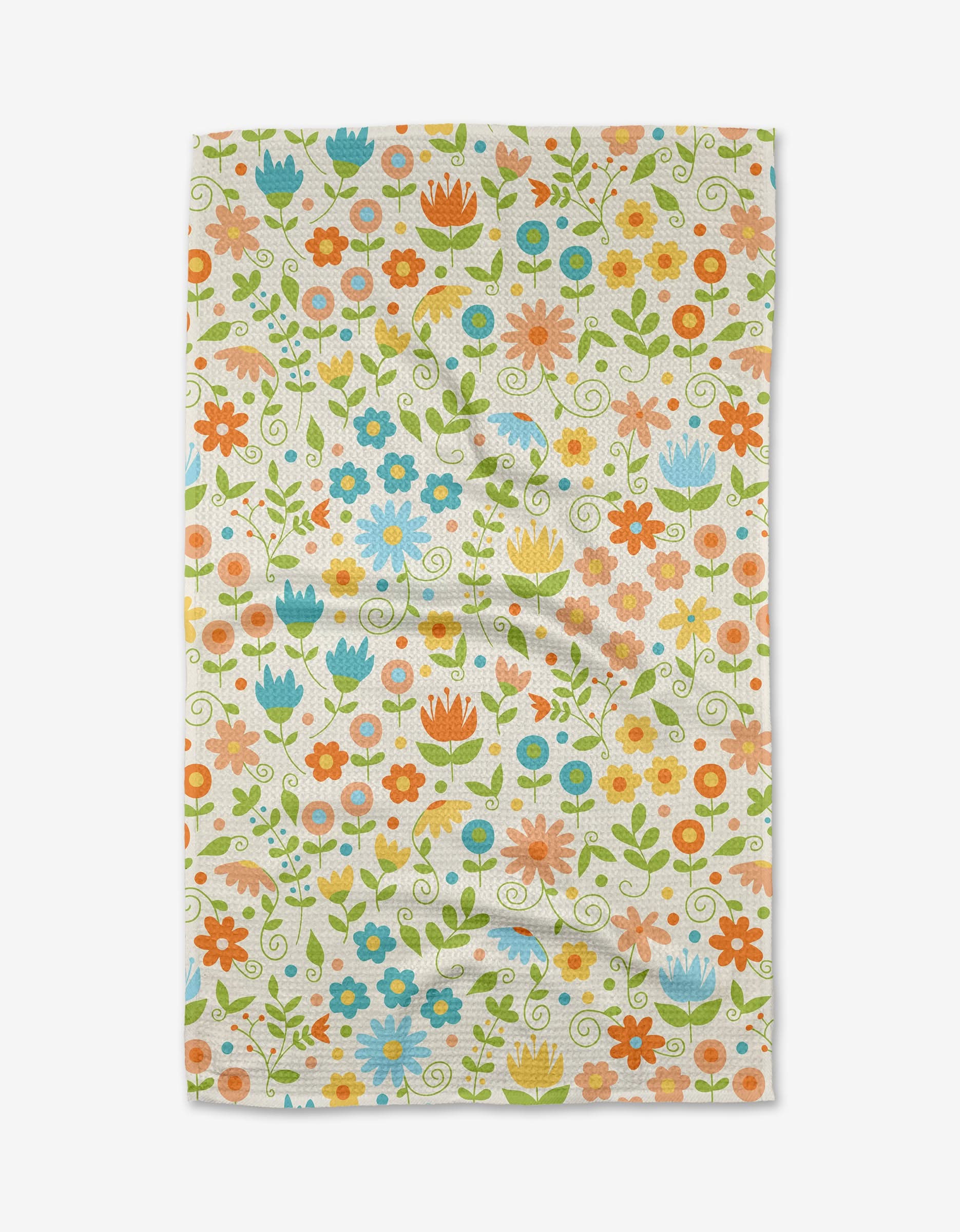 The Remindful Rememberings Tea Towel by Mindfulnice features orange, blue, pink, and yellow flowers with green stems on white. Made from recycled materials, this eco-friendly towel has a slightly wrinkled look.