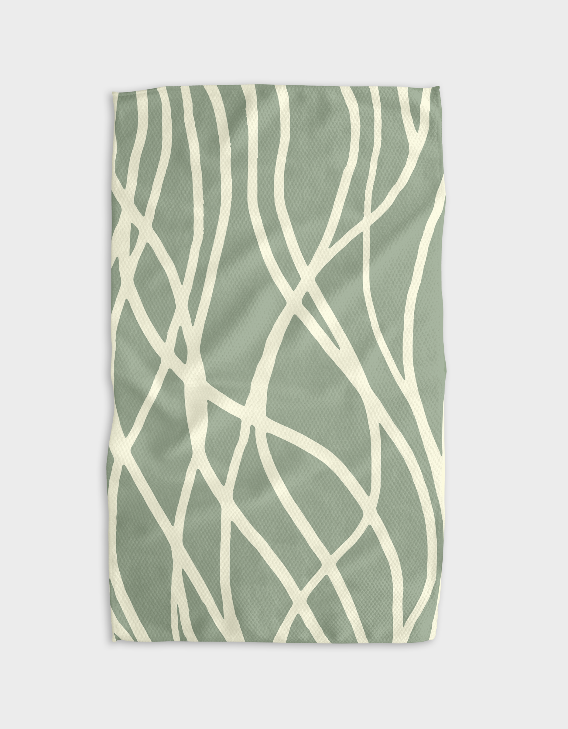The Mint tea towel by GEOMETRY is soft, rectangular, and made from Geoweave™ fabric. It features a green color with cream wavy abstract lines, slight wrinkles, and is shown on a light background.