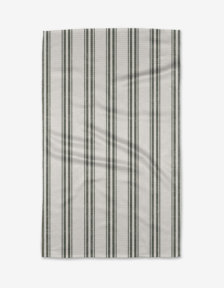 The Becki Owens Spruce tea towel is rectangular, white, and eco-friendly, with evenly spaced vertical dark green and light gray stripes—perfect for everyday kitchen use. Shown flat on a plain white background.