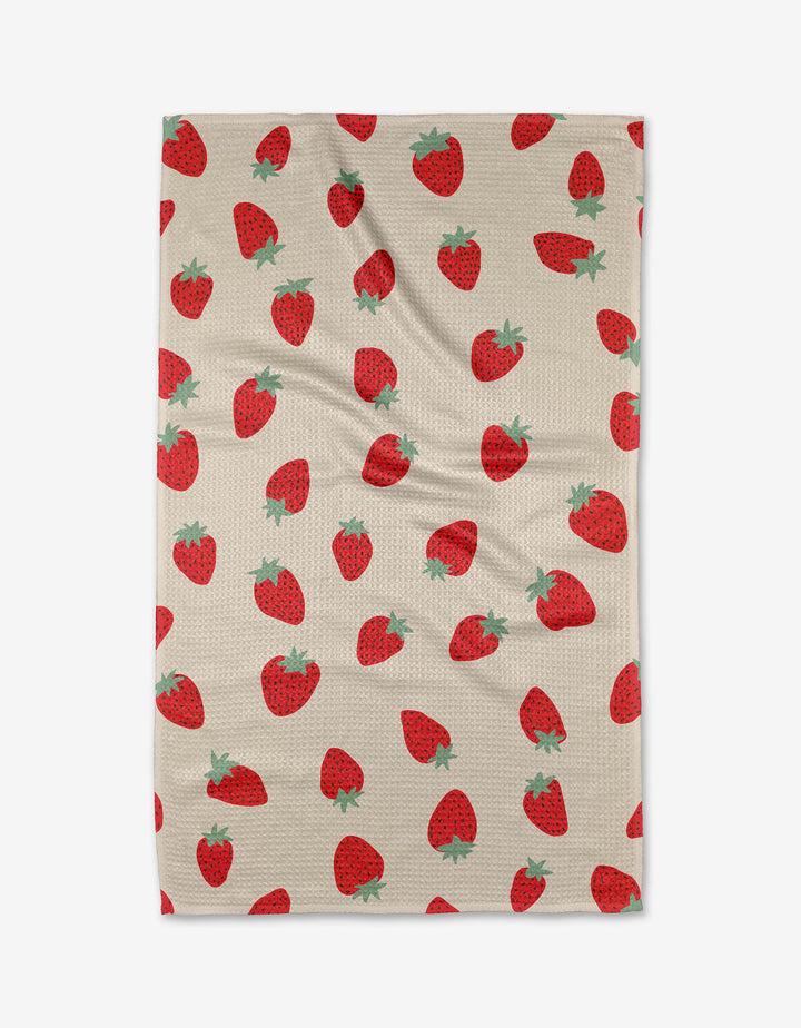 The Purely Kaylie Strawberry Shortcake blanket features a red strawberry pattern with green tops on beige, made from ultra-absorbent Geoweave fabric for style and comfort.