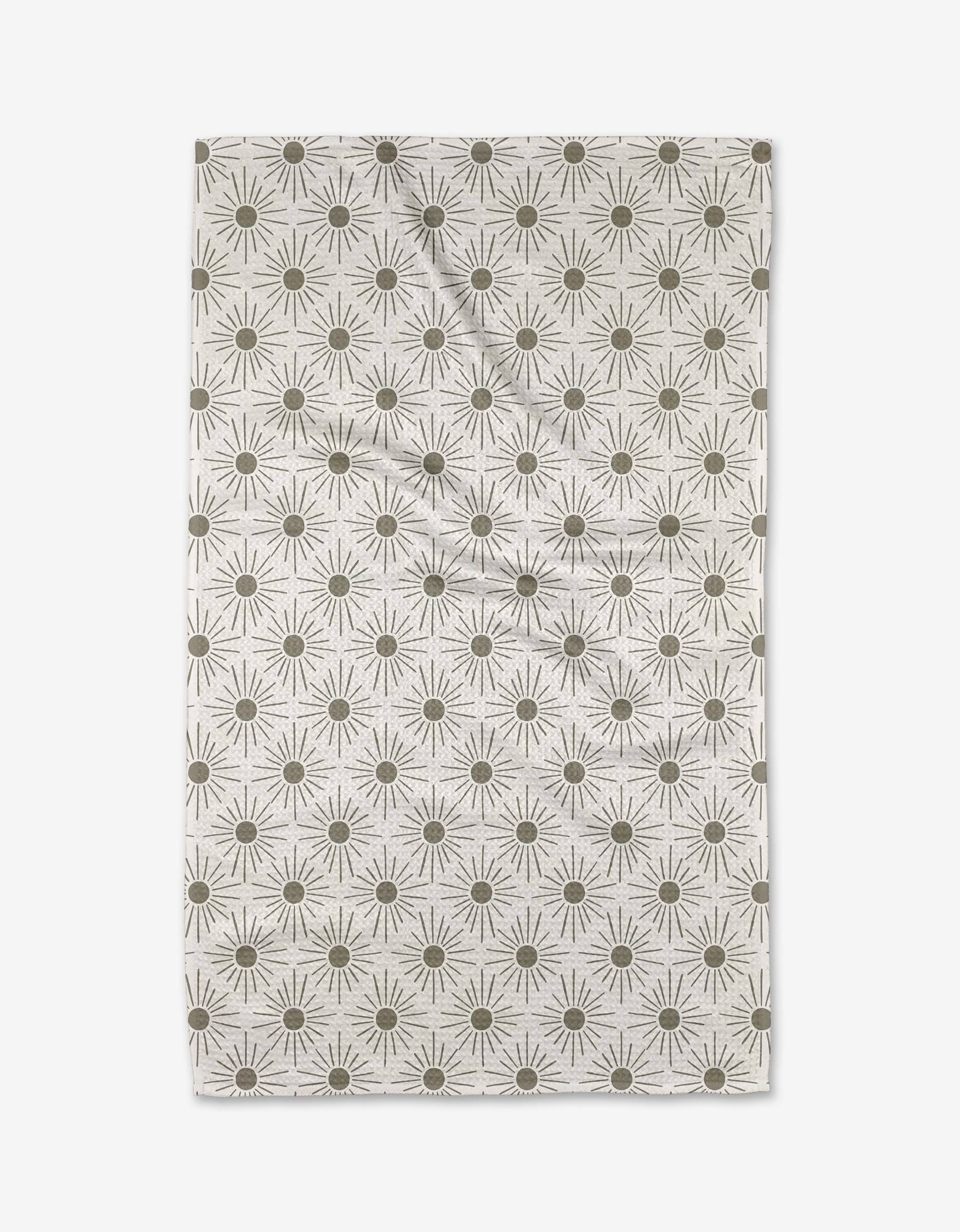 The Hufton Studio Sunny Geo is a rectangular beige cloth featuring evenly spaced olive green sunbursts. Made from ultra-absorbent Geoweave fabric, it has a slightly wrinkled appearance.