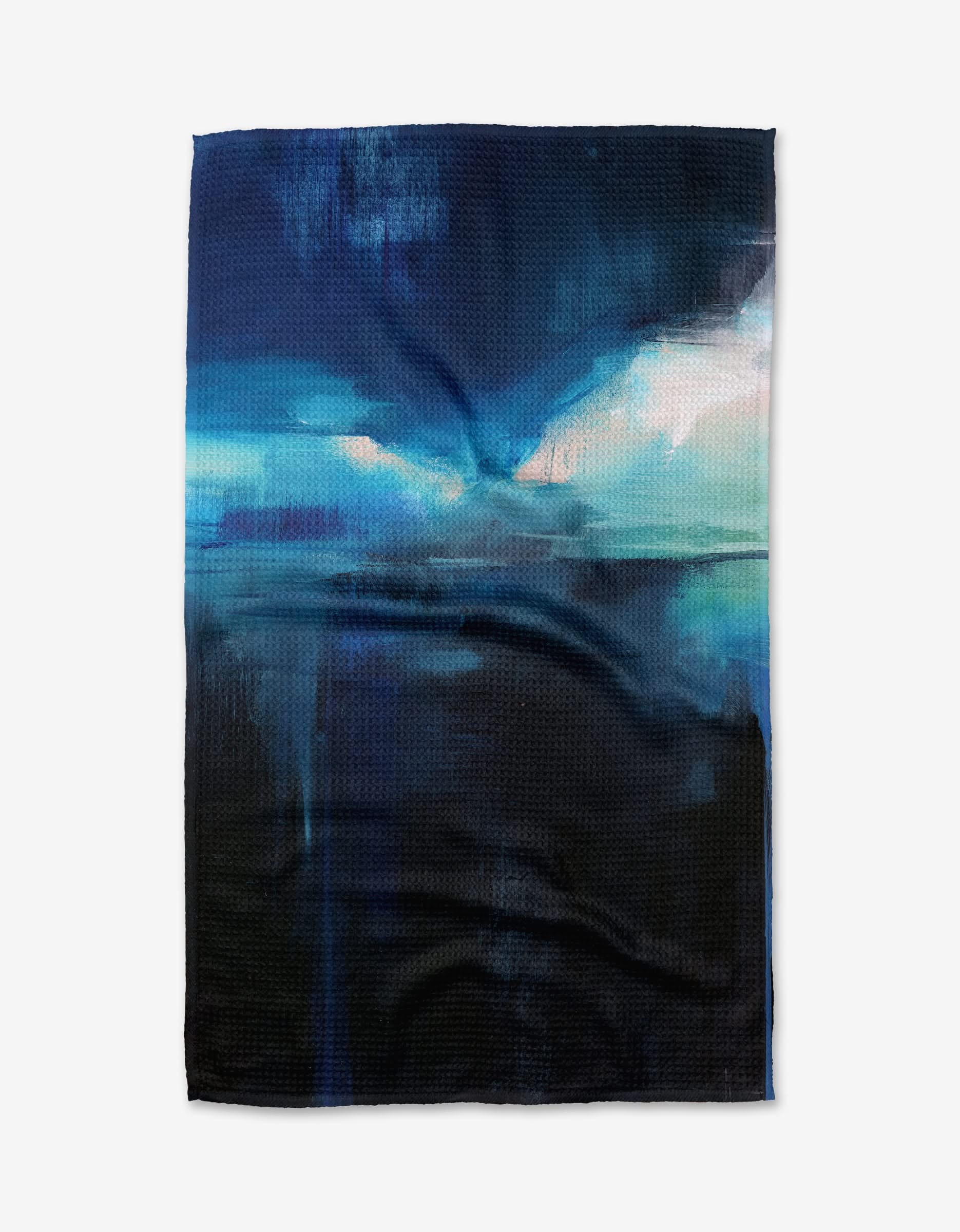 The Ocean Between Us by Jennifer Janesko is an ultra-absorbent towel with an abstract design in dark blue, black, and teal, evoking a dramatic night sky or seascape with bold light and shadow effects.