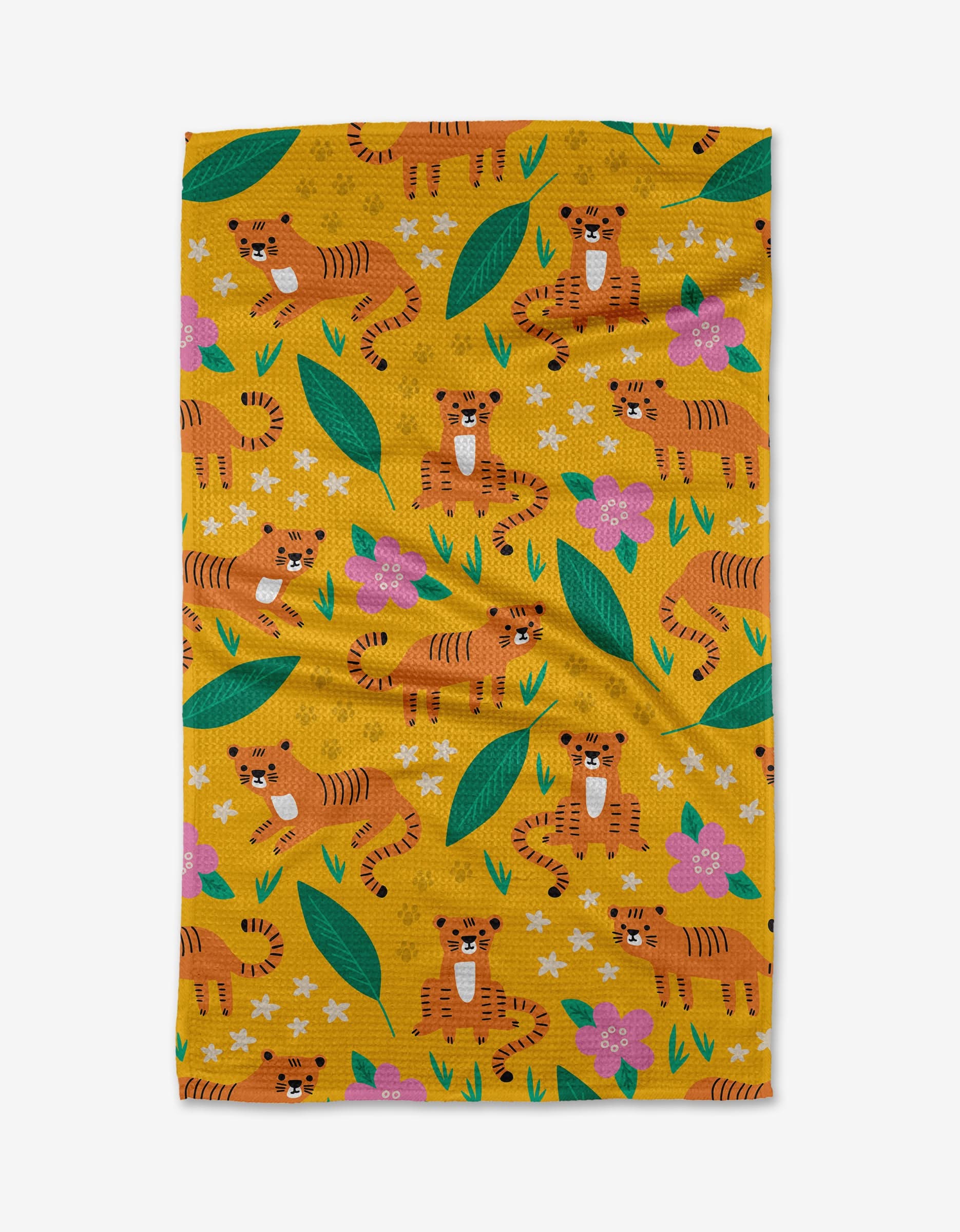 The Tigers tea towel by Genna Blackburn features a playful pattern of cartoon tigers, colorful flowers, green leaves, and white stars on yellow Geoweave™ fabric with visible creases and a vibrant, cheerful design.