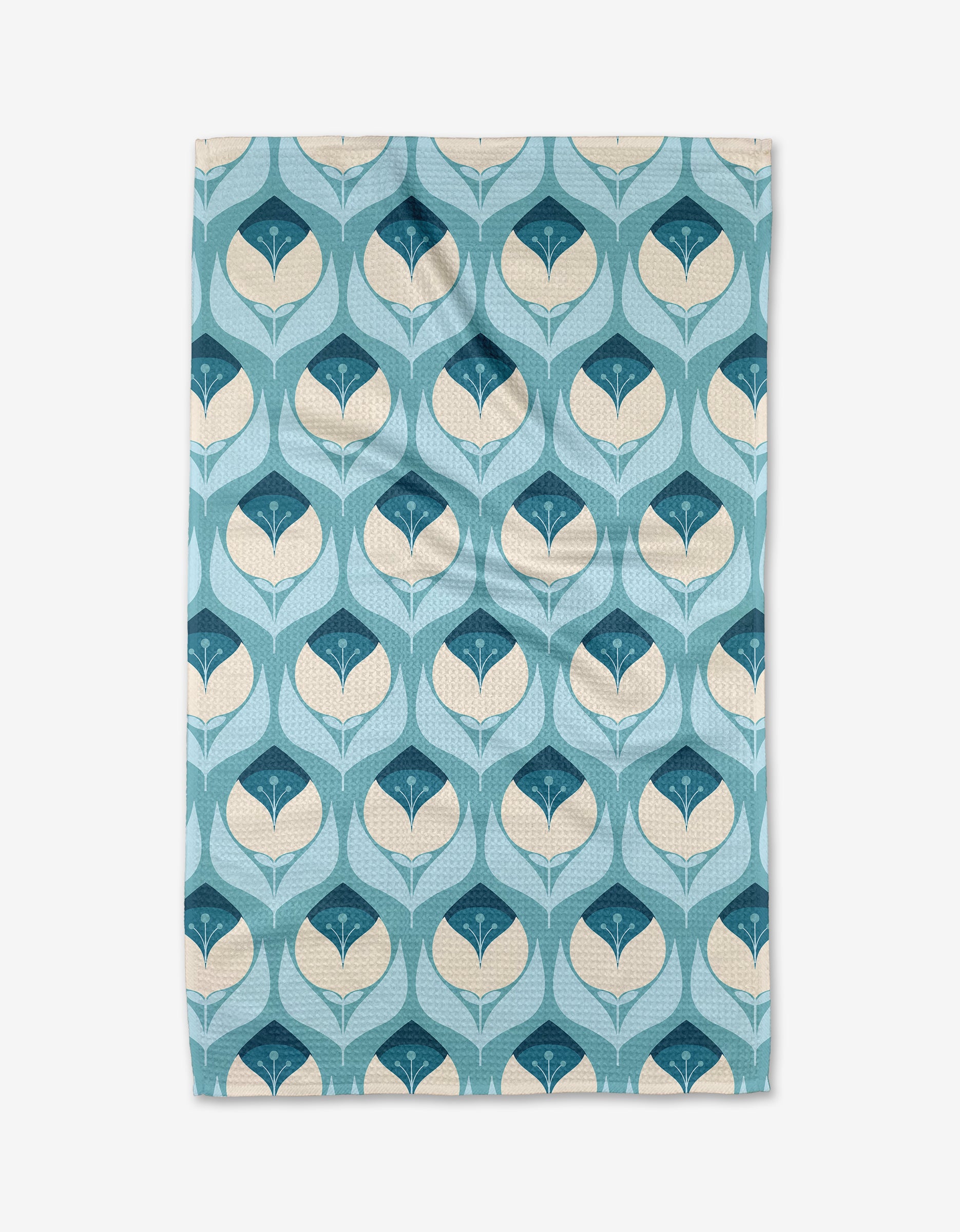 The Blissful Flamingo Winter Florals kitchen towel features a rectangular shape and recycled fabric, with rows of symmetrical, stylized leaves in blue, teal, and cream on a light blue background.