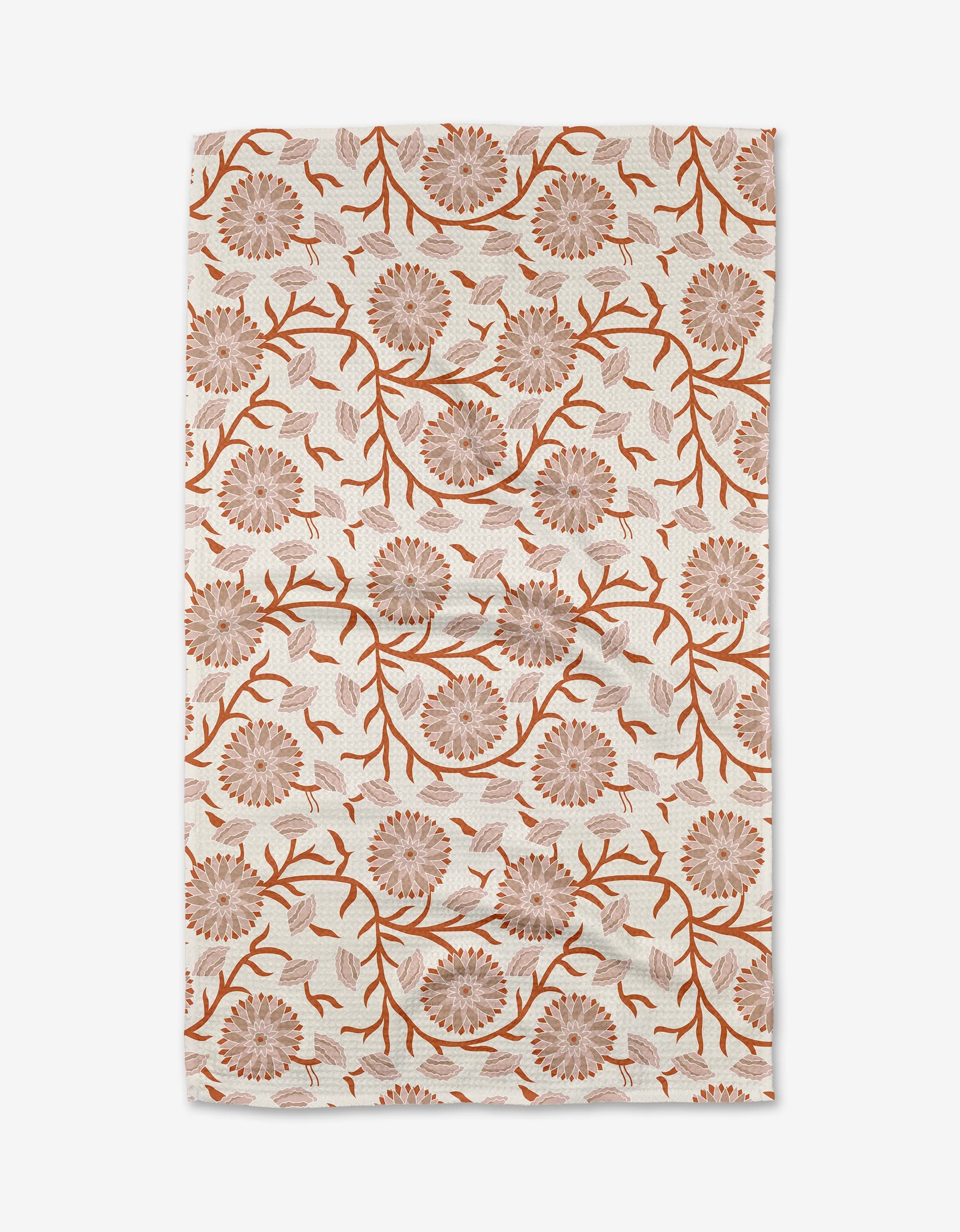 The Dabney Lee Zinnie tea towel is a quick-drying, rectangular cloth made from recycled materials, featuring brown and orange floral patterns with branching stems and leaves on a white background.