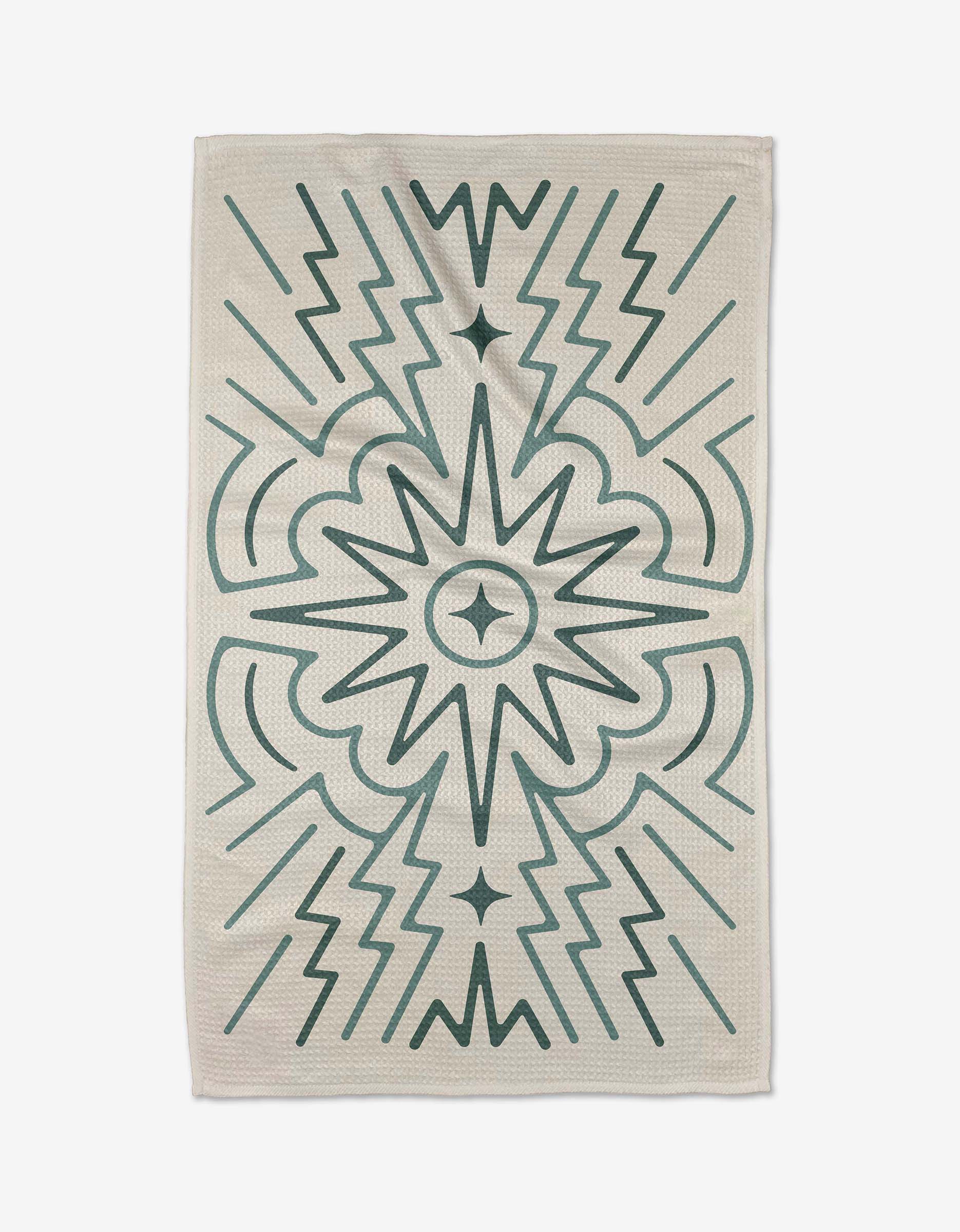 The Sunburst rug by Adam Nienow is rectangular with a cream background and symmetrical dark green geometric patterns—zigzags, arrows, and a central starburst—crafted from recycled materials.