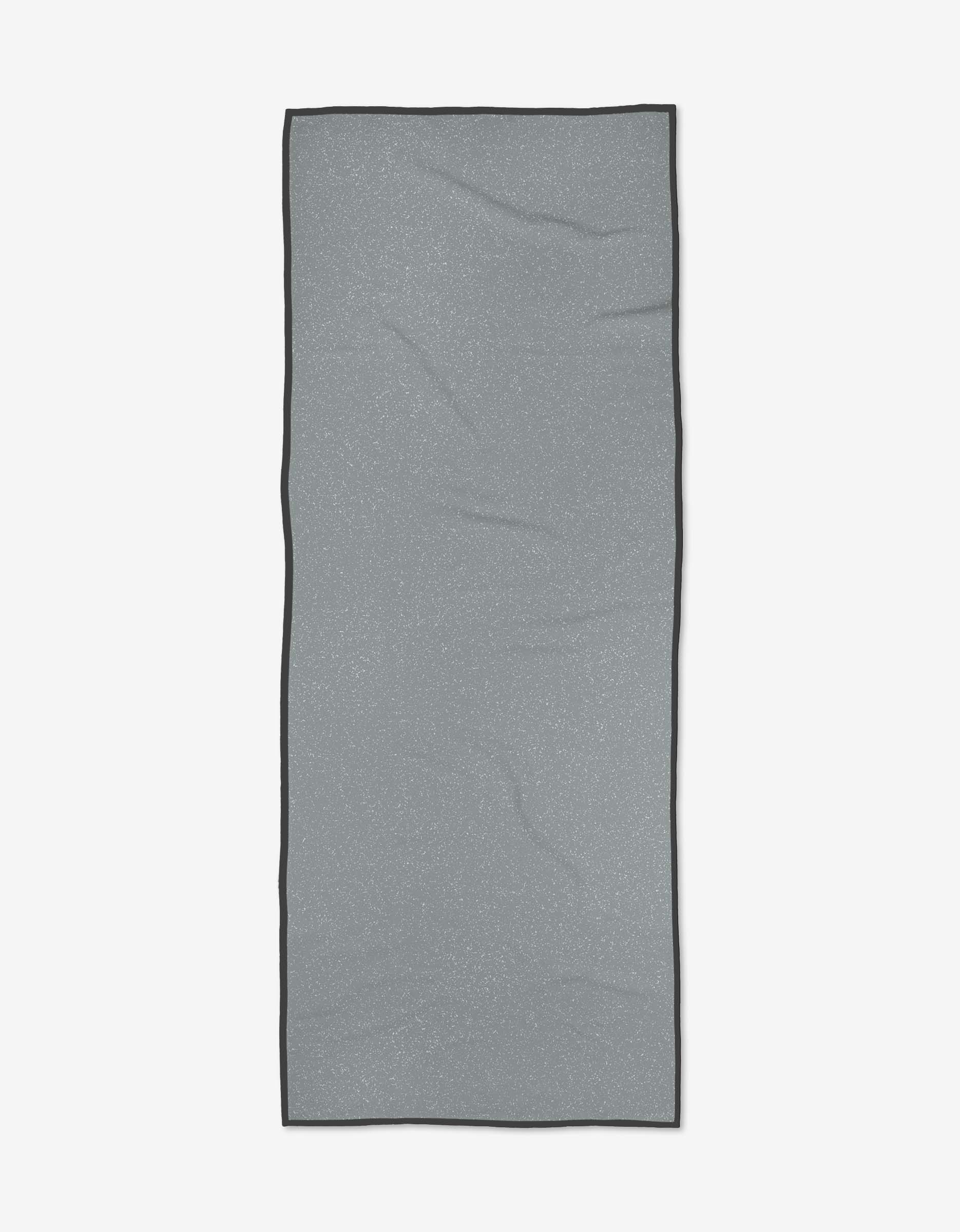 The GEOMETRY Zen Summer is a rectangular light gray yoga towel with subtle wrinkles and a dark gray border, made from recycled materials and shown on a plain white background.